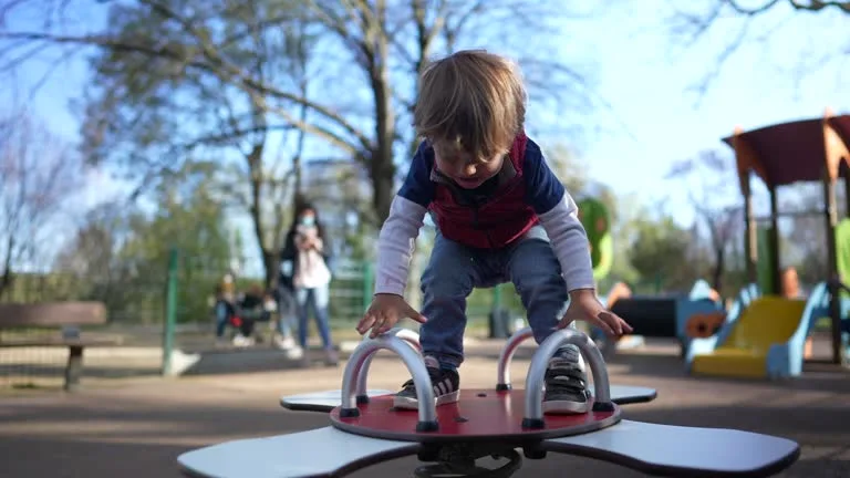 Enfant jouant sur une aire de jeux extérieur Photo d'un petit garçon jouant sur une plateforme de jeu extérieur